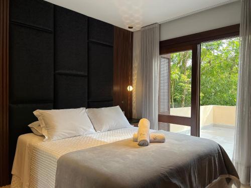 Un dormitorio con una cama con un osito de peluche. en Apartamento Morada dos Tucanos 1 dorm by Achei Gramado, en Gramado