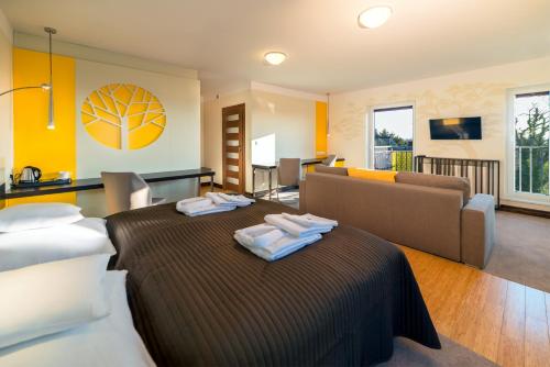 ヤストシェンビャ・グラにあるVilla Buki Pokoje & SPAのベッドルーム1室(ベッド2台付)、リビングルームが備わります。