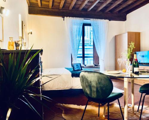sypialnia z łóżkiem i stołem z laptopem w obiekcie La Mandorla studio apartment in Piazza del Duomo we Florencji