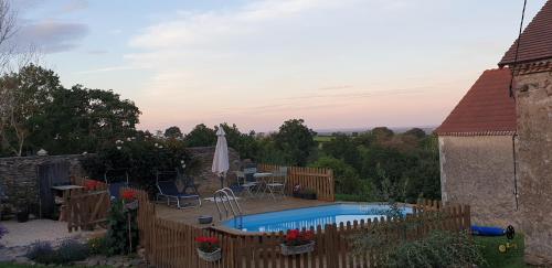a backyard with a pool and a table and chairs at Chambres d'Hôtes Maison Balady in Bellenaves