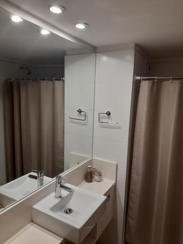 een badkamer met een wastafel en een spiegel bij Bellagio Tower in Punta del Este