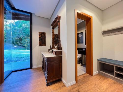 Habitación con baño con espejo y lavabo. en Incrível Casa Araucária 3 Suítes by Achei, en Canela