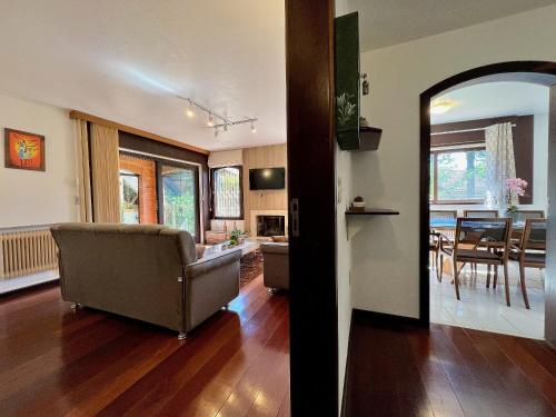 uma sala de estar com um sofá e uma sala de jantar em Casa Allegro 3dorm prox Lago Negro by AcheiGramado em Gramado