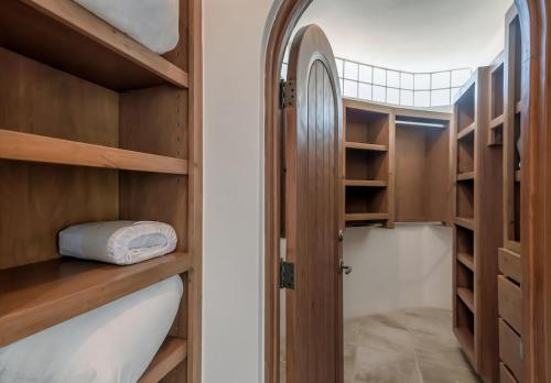 a closet with wooden shelves and a door at The one and only Pedregal Hollywood House in Cabo San Lucas