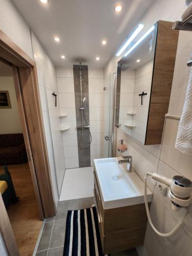 mała łazienka z umywalką i prysznicem w obiekcie am Mühlbach - Pension Luttinger w mieście Bichlbach