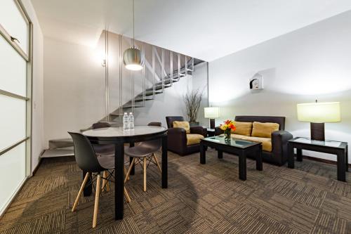 a living room with a table and chairs and a couch at Suites Teca Once in Mexico City