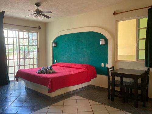 a bedroom with a red bed and a green wall at HOTEL ATLANTIDA in Playa del Carmen