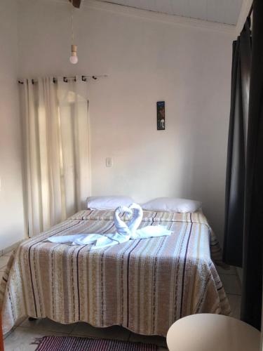 a bedroom with a bed with a towel on it at Pousada King Stones - São Thomé das Letras - ÁREA CENTRAL in São Thomé das Letras