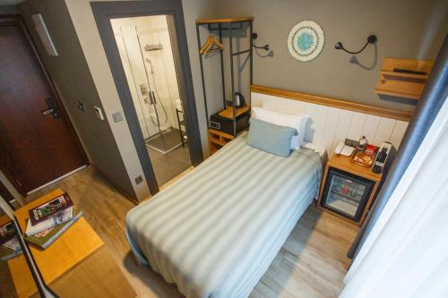 a small bedroom with a bed and a shower at Istanbul Old City Colorful Houses Balat PETRION Hotel in Istanbul