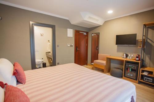 a hotel room with a bed and a television at Istanbul Old City Colorful Houses Balat PETRION Hotel in Istanbul