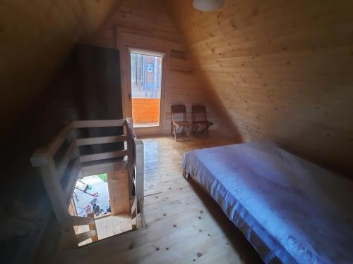 ein Schlafzimmer mit einem Bett in einer Holzhütte in der Unterkunft Brvnare Borove iglice in Vinci