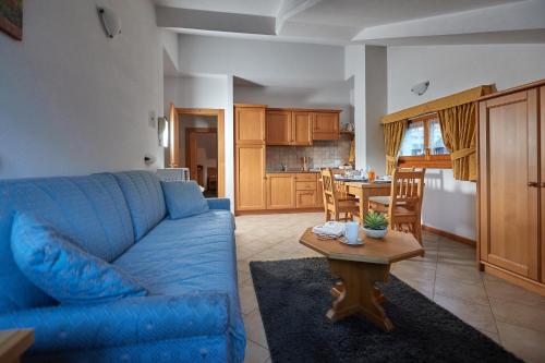 a living room with a blue couch and a table at Residence Sci Sport in Bormio