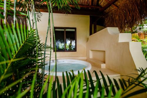 a jacuzzi tub in a house with plants at Hotel Rancho Encantado in Bacalar