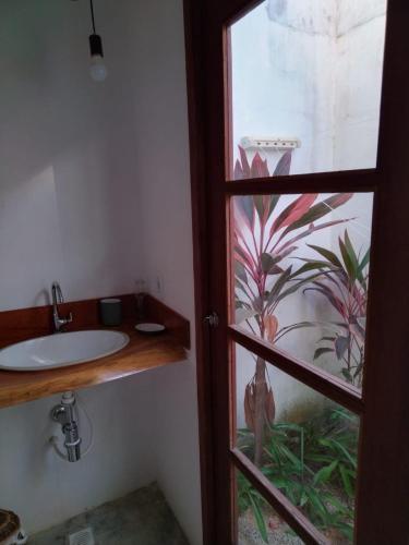a bathroom with a sink and a window at Dona Maragô Pousada in Maragogi