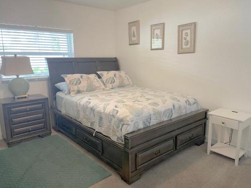 um quarto com uma cama, um candeeiro e uma mesa de cabeceira em Beautiful Bright & Sparkling 2Bed 1Bath Beach Retreat - Unit 212 em Cocoa Beach