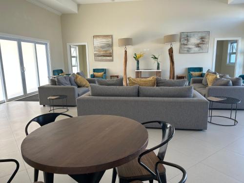 a living room with a couch and a table and chairs at Seamist villa @Oceanpointe Lucea comfy 2BR w/pool gym & parking in Lucea