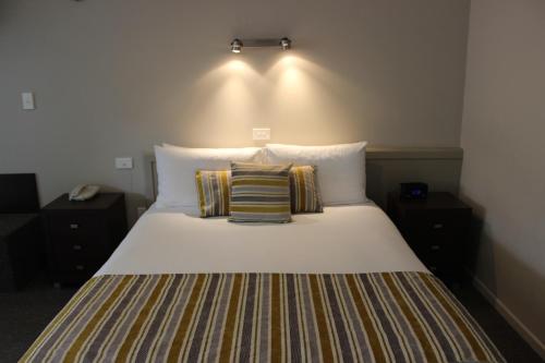 1 cama con 2 almohadas en una habitación en Quality Inn Acapulco Taupo, en Taupo