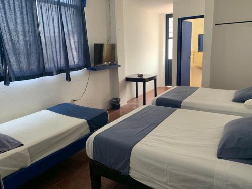 Una cama o camas en una habitación de Hotel & Hostal Mayflower
