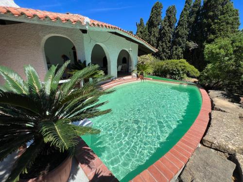 a swimming pool in front of a house at Casale al mare - villa with swimming pool 150 meters from the beach in Porto Columbu - Perdʼe Sali
