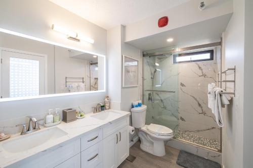 a white bathroom with a toilet and a shower at Waikiki Upscale 1 BR - Ocean Views - Parking in Honolulu