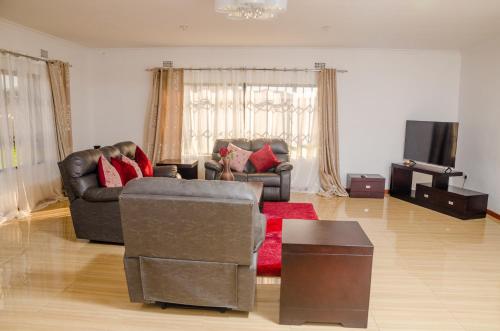 - un salon avec deux canapés et un tapis rouge dans l'établissement Carsi holiday Villa, à Lusaka