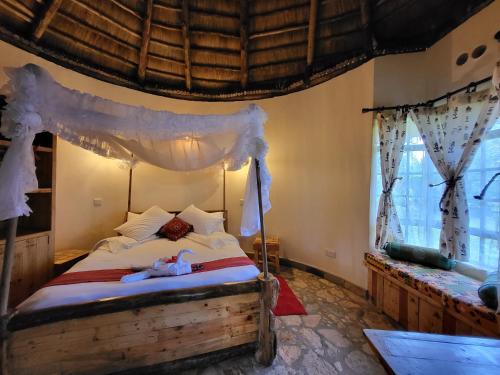 a bedroom with a bed with a canopy at Edaala Comfort - Cottage Rooms in Nairobi