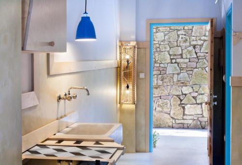 baño con lavabo y pared de piedra en Villa Rossa en Parga