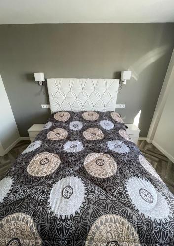 a bedroom with a bed with a quilt on it at Piso playa Maktub in Puerto Real
