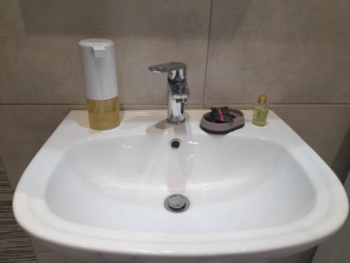 a white sink with a bottle and a glass on it at Stbs Luxury, Nea Fokea in Nea Fokea