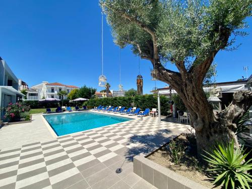 a swimming pool with a tree next to a tree at EllinFos ApartHotel in Hanioti