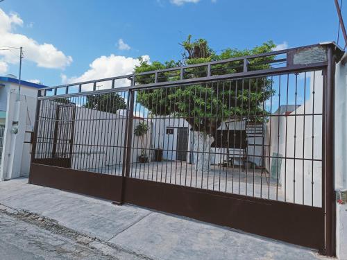 a metal gate with a tree behind it at La casita del árbol, amplia y cómoda en barrio familiar in Campeche