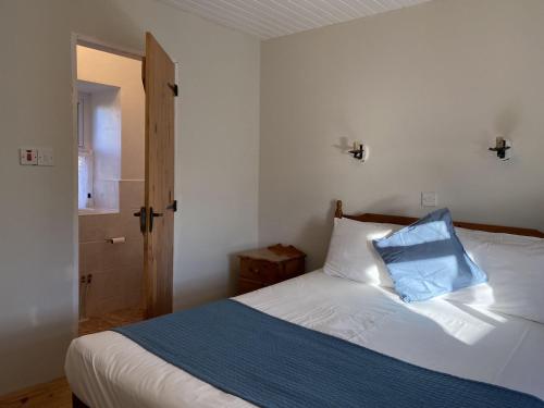 a bedroom with a bed with a blue pillow on it at Cottage 433 - Ballyconneely in Ballyconneely