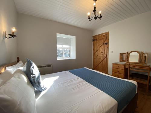 a bedroom with a large bed and a window at Cottage 433 - Ballyconneely in Ballyconneely