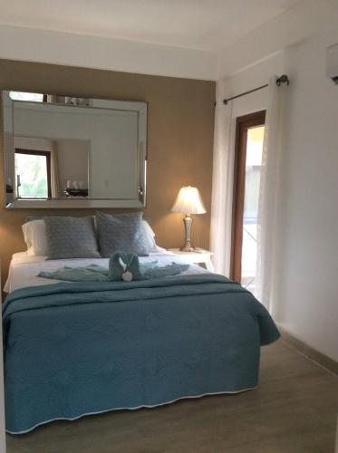 a bedroom with a blue bed with a teddy bear on it at Beach Side Condos Caye Caulker by CCVH in Caye Caulker