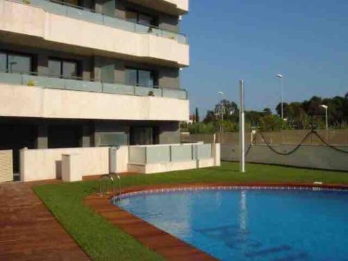une piscine en face d'un bâtiment dans l'établissement Exclusivo piso con terraza al lado de la playa, à Lloret de Mar