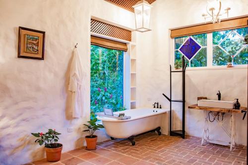 uma casa de banho com uma banheira, um lavatório e uma janela em Exclusive Hotel Don Ernesto By La Chimba em San José
