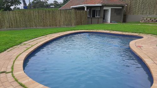 a swimming pool in a yard with a fence at The Gregory in Pinetown