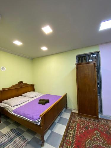 1 dormitorio con 1 cama con colchón morado en Vahe’s family guests house en Ereván