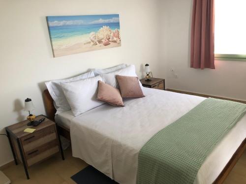 a bedroom with a bed with white sheets and pillows at Celia in Adamas