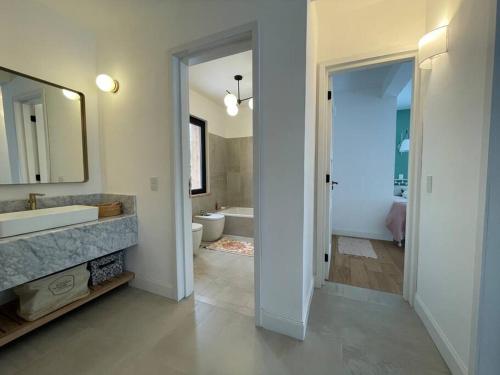 a bathroom with a tub and a sink and a mirror at Imponente casa en Arelauquen Golf & Country Club in San Carlos de Bariloche