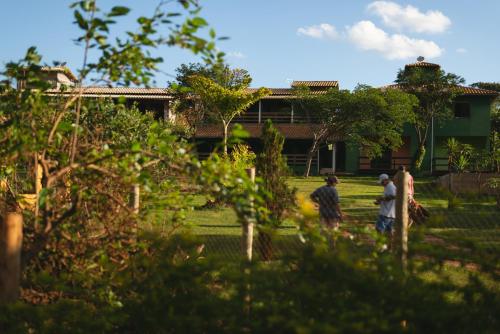 two people standing in the yard of a house at Pousada Bela Vista do Ismail - Lapinha da Serra in Santana do Riacho