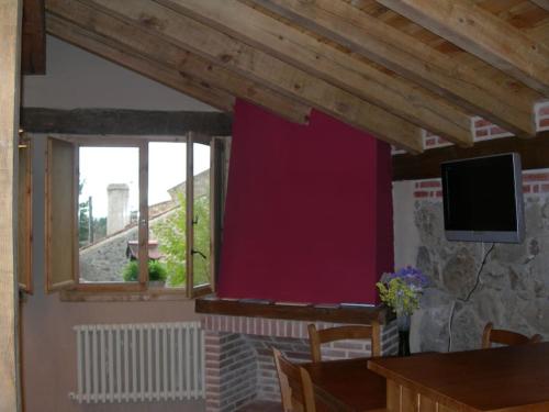 sala de estar con pared roja y ventana en Apartamento Rural en Sotosalbos, en Sotosalbos