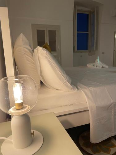 a bedroom with a bed with a candle on a table at La Marinella in Faccia di Trippa