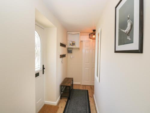a hallway with a door and a table at Orchard House Cottage in Malmesbury