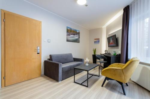 a living room with a couch and a chair and a table at Pensjonat Śnieżka SPA in Karpacz