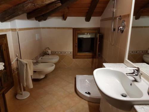 ein Badezimmer mit 2 WCs, einem Waschbecken und einem Waschbecken in der Unterkunft La Teggia in Monte San Pietro