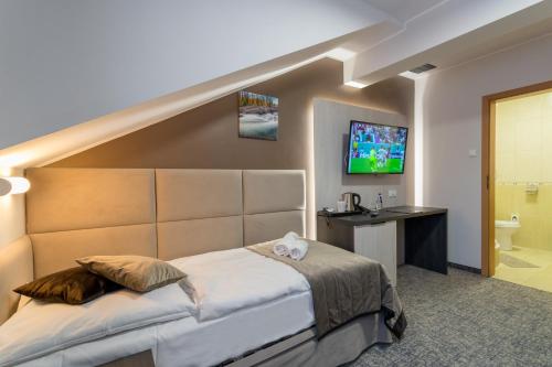 a hotel room with a bed and a bathroom at Pensjonat Śnieżka SPA in Karpacz
