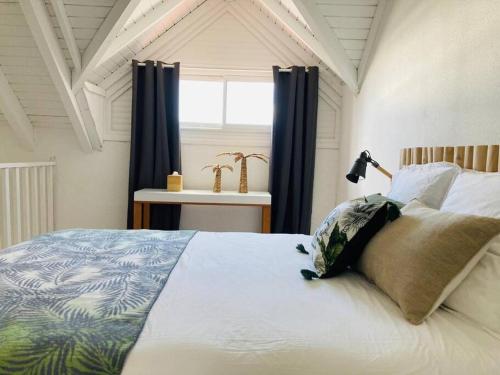Baie Nettle的住宿－Love Spot Appartement，一间卧室配有一张带蓝色窗帘的大床