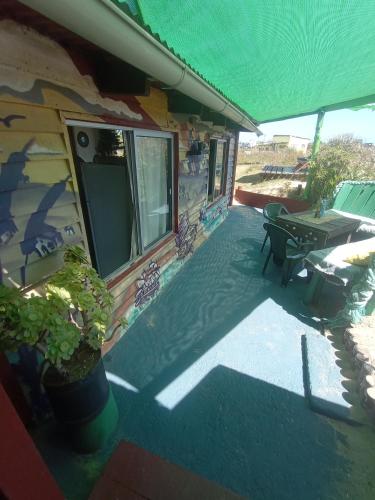 a porch of a house with a table and a patio at Green House Hostel in Cabo Polonio