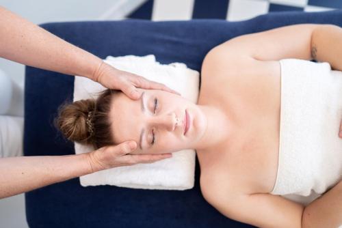 a woman laying on a blue couch getting a massage at Hotel Zum Ochsen in Schonwald im Schwarzwald